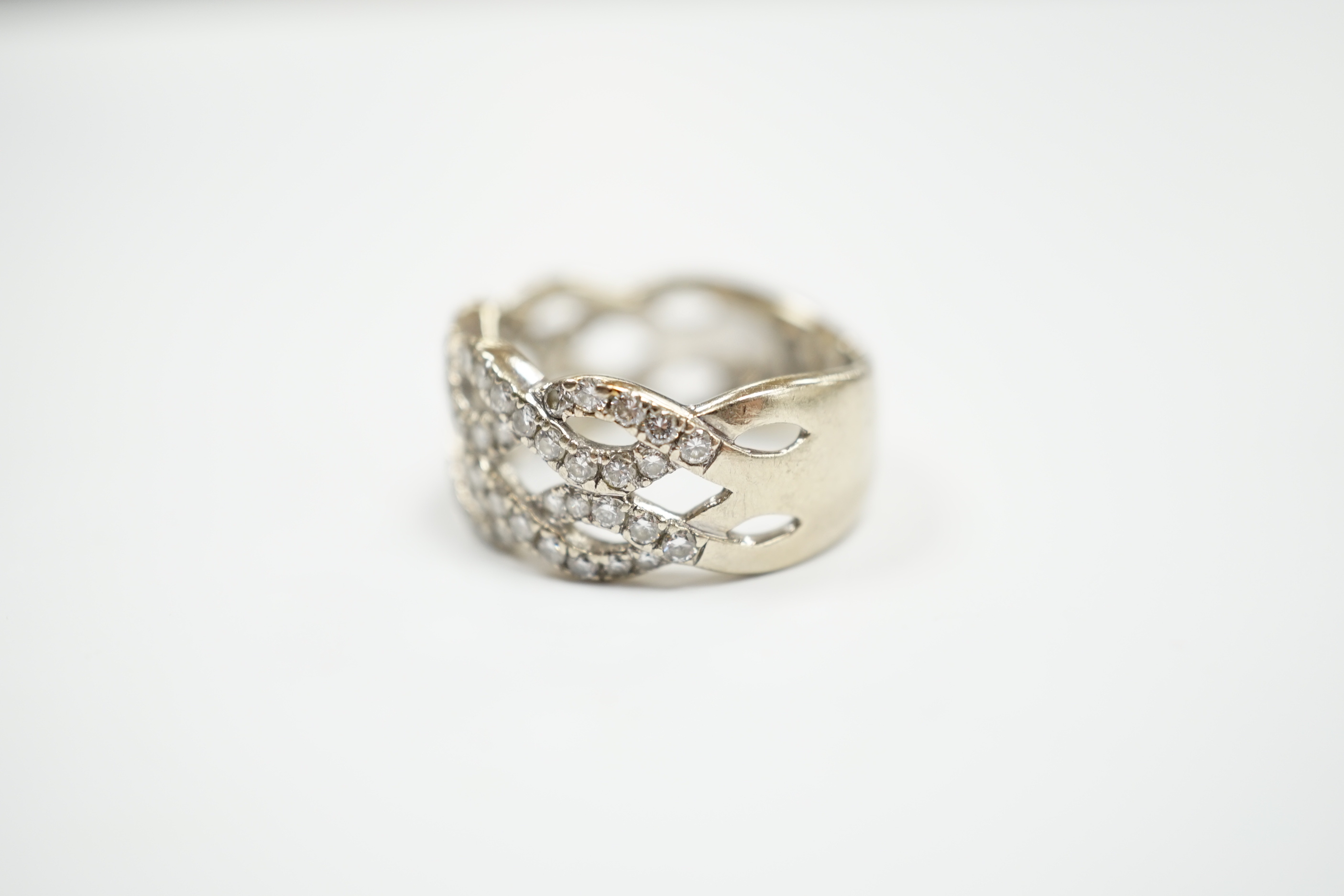 A modern 14k white metal and diamond chip cluster set dress ring, of interwoven design, size M, gross weight 6.4 grams.